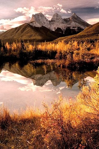 The Three Sisters reflected in the lake near Canmore, Alberta, Canada